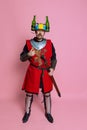 Full-length portrait of funny looking man, medieval warrior or knight in beer helmet and protective armor isolated over Royalty Free Stock Photo