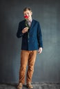 Full length portrait of funny man eating red rose Royalty Free Stock Photo