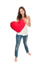 Full length portrait of a gorgeous smiling woman holding a red heart pillow