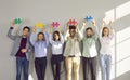 Full length portrait of a group of business people holding jigsaw pieces with hands up. Royalty Free Stock Photo