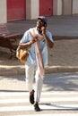 Full length handsome african man walking outside in the city talking on phone Royalty Free Stock Photo