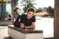 Full length portrait of handsome Caucasian man lying on bench at university campus on sunny day Royalty Free Stock Photo