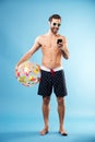 Full length portrait of a handsome guy holding beach ball Royalty Free Stock Photo