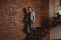 A full length portrait of a handsome stylish man posing in loft studio interior. Fashion for men Royalty Free Stock Photo