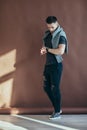 Full length portrait of handsome stylish man looking at his watch Royalty Free Stock Photo