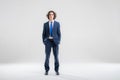 Full-length portrait of a handsome young man in a dark blue business suit on a white background Royalty Free Stock Photo