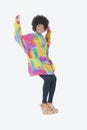 Full length portrait of happy African American woman in dashiki dancing over gray background