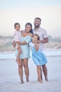 Full length portrait of a happy mixed race family standing together on the beach. Loving parents spending time with Royalty Free Stock Photo