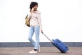 Full length happy travel woman walking with suitcase and talking on mobile phone Royalty Free Stock Photo