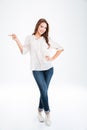 Full length portrait of a happy woman pointing finger away Royalty Free Stock Photo