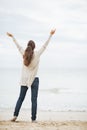 Full length portrait of happy woman in sweater rejoicing on beach Royalty Free Stock Photo