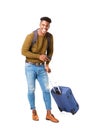 Full length happy young black man standing against isolated white background with travel bags and cellphone Royalty Free Stock Photo