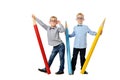 Full length portrait happy young boys in glasses and bowtie posing near huge colorful pencils. Educational concept. Isolated over