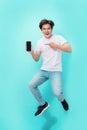 Full length portrait of a happy young man in white t-shirt point Royalty Free Stock Photo