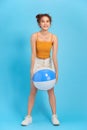 Full length portrait of happy young woman with beach ball Royalty Free Stock Photo