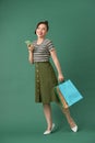 Full length portrait of a happy young woman holding shopping bags and mobile phone Royalty Free Stock Photo