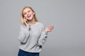 Full length portrait of a happy young woman talking on the phone isolated on a gray background Royalty Free Stock Photo