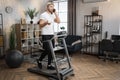 Blond bearded male in white t-shirt jogging on treadmill. Royalty Free Stock Photo