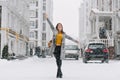 Full-length portrait of inspired female model in stylish coat posing with pleasure in winter city. Outdoor photo of glad