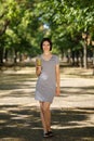 Amazing woman with a green cocktail. Vegan girl walking on a park background. Vegetarian lifestyle concept. Copy space. Royalty Free Stock Photo