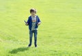 Full length portrait kid jumping in the green grass, Cute little boy playing plastic airplane toy, Child having fun playing Royalty Free Stock Photo