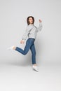 Full length portrait of a laughing woman jumping over gray background Royalty Free Stock Photo