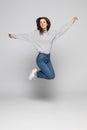 Full length portrait of a laughing woman jumping over gray background Royalty Free Stock Photo