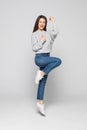 Full length portrait of a laughing woman jumping over gray background Royalty Free Stock Photo