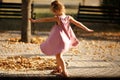 Full length portrait of a little girl dancing in the park a warm Royalty Free Stock Photo