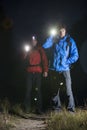 Full length portrait of male backpackers with flashlights in field at night Royalty Free Stock Photo