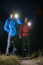 Full length portrait of male backpackers with flashlights in field at night Royalty Free Stock Photo