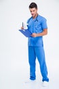 Full length portrait of a male doctor reading clipboard Royalty Free Stock Photo