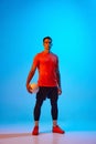 Full-length portrait of male volleyball player posing with ball isolated on blue studio background in neon light. Sport Royalty Free Stock Photo