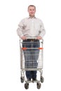 A full length portrait of a man pushing an empty shopping cart