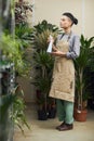 Woman Watering Plants in Shop