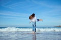 Caring mother playing with little daughter, spinning her around, running barefoot on the waves on Atlantic ocean beach Royalty Free Stock Photo