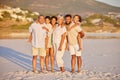 Full length portrait of a multi generation family on vacation standing together at the beach on a sunny day. Mixed race Royalty Free Stock Photo