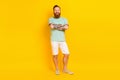 Full length portrait of nice satisfied glad young man crossed arms posing isolated on yellow color background Royalty Free Stock Photo