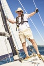 Full-length portrait of a pensioner on the background of the port marina. Fashionable senior fisherman in a hat and breeches looki