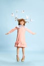 Full-length portrait of playful little girl, child in pink dress posing against blue studio background. Fantasy and Royalty Free Stock Photo