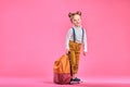 Full length portrait of a schoolgirl standing on pink background Royalty Free Stock Photo