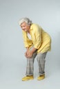 Full length portrait of senior woman  knee problems on grey background Royalty Free Stock Photo