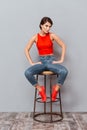 Full length portrait of a serious girl sitting on chair Royalty Free Stock Photo