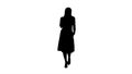 Silhouette Portrait of walking happy young woman talking on mobile phone and smiling. Royalty Free Stock Photo