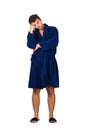 Full length portrait of sleepy young man wears blue bathrobe holding hand to forehead, eyes closed feel tired needs to sleep Royalty Free Stock Photo