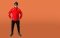 full length portrait of smiley hiker with glasses and helmet. isolated on orange background