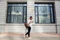 African american woman with backpack walking outdoor and talking on mobile phone Royalty Free Stock Photo