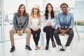 Full length portrait of smiling business people sitting on chair Royalty Free Stock Photo