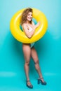 Full length portrait of a smiling girl dressed in swimsuit posing with inflatable ring isolated over blue background Royalty Free Stock Photo