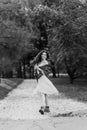 Full length portrait of a smiling girl wear in dress, in a park at trees background. Photo black and white Royalty Free Stock Photo